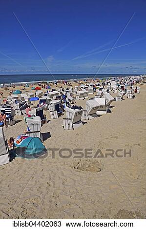 Stock Image - Tourist and beach chairs, the main beach of Westerland, Sylt, North Frisian Islands, North Frisia, Schleswig-Holstein, Germany, Europe. Fotosearch