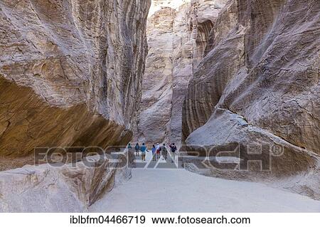 Stock Photo - Tourists in rocky gorge, Siq al-Siq, deserted city of Petra, Jordan, Asia. Fotosearch