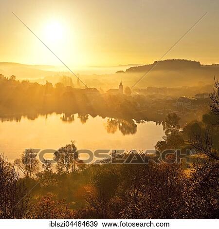 Town with church near lake, Schalkenmehrener Maar in autumn at sunrise, water reflection, Schalkenmehren, Daun, Vulkaneifel, Eifel, Rhineland-Palatinate, Germany, Europe View Large Photo Image Stock Photo - Town with church near lake, Schalkenmehrener Maar in autumn at sunrise, water reflection, Schalkenmehren, Daun, Vulkaneifel, Eifel, Rhineland-Palatinate, Germany, Europe. Fotosearch