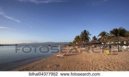 Stock Image - Tropical beach with palm trees at the Hotel Club Amigo Costa Sur, evening light, Playa Ancon, near Trinidad, Sancti Spiritus Province, Cuba, Central America. Fotosearch