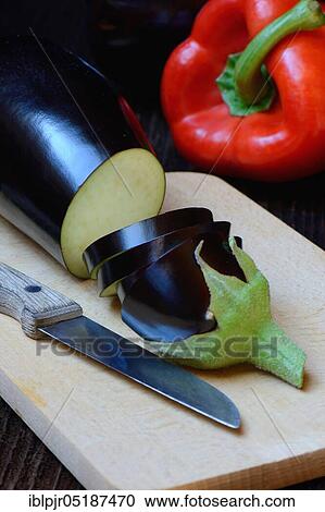 Stock Image - Truncated Egg plant ( Solanum melongena) with knife and paprika. Fotosearch