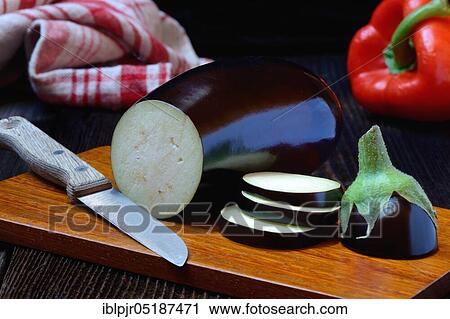 Stock Image - Truncated Egg plant ( Solanum melongena) with knife and paprika. Fotosearch