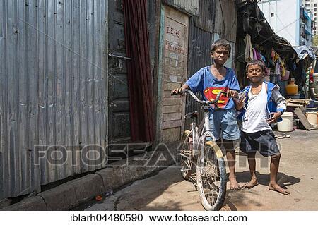 Stock Image - Two children with bicycle, the largest slum in Asia, Dharavi, Mumbai, Maharashtra, India, Asia. Fotosearch