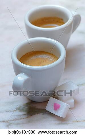 Stock Image - Two cups of espresso with sugar cubes. Fotosearch