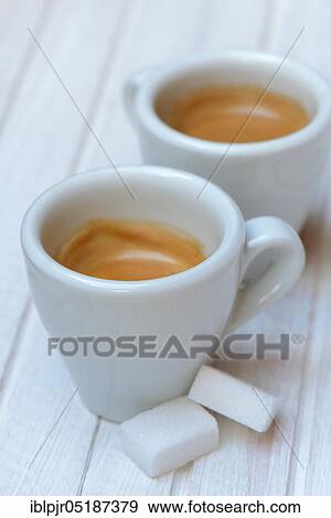 Stock Photo - Two cups of espresso with sugar cubes. Fotosearch