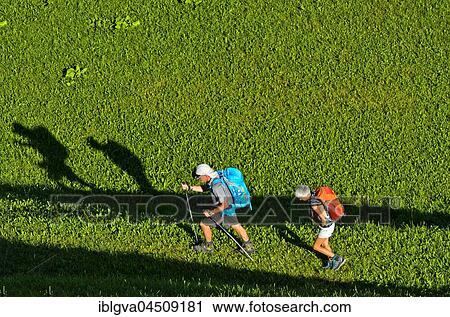 Two hikers crossing a meadow and casting shadows, hiking area St. Antönien, Prättigau, Canton of Grisons, Switzerland, Europe View Large Photo Image Stock Image - Two hikers crossing a meadow and casting shadows, hiking area St. Antönien, Prättigau, Canton of Grisons, Switzerland, Europe. Fotosearch