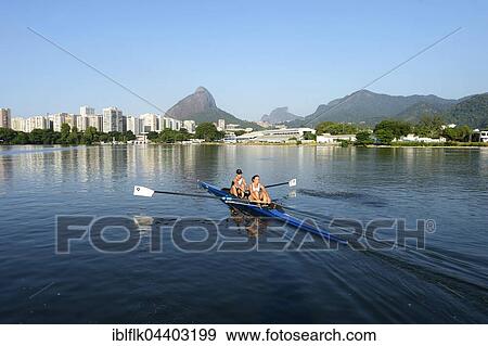 Two young women participating in early morning rowing training in the Lagoa Rodrigo de Freitas Lagoon, with Rio de Janeiro skyline and Sugar Loaf Mountain, Lagoa District, Rio de Janeiro, Brazil, South America View Large Photo Image Stock Photo - Two young women participating in early morning rowing training in the Lagoa Rodrigo de Freitas Lagoon, with Rio de Janeiro skyline and Sugar Loaf Mountain, Lagoa District, Rio de Janeiro, Brazil, South America. Fotosearch