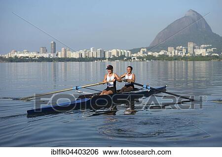 Two young women participating in early morning rowing training in the Lagoa Rodrigo de Freitas Lagoon, with Rio de Janeiro skyline and Sugar Loaf Mountain, Lagoa District, Rio de Janeiro, Brazil, South America View Large Photo Image Stock Photograph - Two young women participating in early morning rowing training in the Lagoa Rodrigo de Freitas Lagoon, with Rio de Janeiro skyline and Sugar Loaf Mountain, Lagoa District, Rio de Janeiro, Brazil, South America. Fotosearch