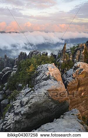 Stock Photo - View over Schrammsteine, fog over the Elbe valley, Bad Schandau, Saxon Switzerland, Elbe Sandstone Mountains, Saxony, Germany, Europe. Fotosearch