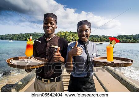 Waiters serving cocktails on a long wooden pier in the Bom Bom Resort, Unesco biosphere reserve, Principe, Sao Tome and Principe, Atlantic Ocean, Africa View Large Photo Image Picture - Waiters serving cocktails on a long wooden pier in the Bom Bom Resort, Unesco biosphere reserve, Principe, Sao Tome and Principe, Atlantic Ocean, Africa. Fotosearch