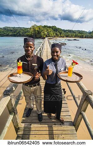Waiters serving cocktails on a long wooden pier in the Bom Bom Resort, Unesco biosphere reserve, Principe, Sao Tome and Principe, Atlantic Ocean, Africa View Large Photo Image Stock Photography - Waiters serving cocktails on a long wooden pier in the Bom Bom Resort, Unesco biosphere reserve, Principe, Sao Tome and Principe, Atlantic Ocean, Africa. Fotosearch