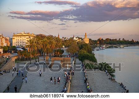 Waterfront promenade Muelle de la sal at the river Rio Guadalquivir with Monumento a la Tolerancia and Torre del Oro, sunset, Sevilla, Andalusia, Spain, Europe View Large Photo Image Picture - Waterfront promenade Muelle de la sal at the river Rio Guadalquivir with Monumento a la Tolerancia and Torre del Oro, sunset, Sevilla, Andalusia, Spain, Europe. Fotosearch