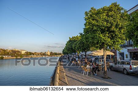 Waterfront promenade on Calle Betis in Triana with the river Rio Guadalquivir, in the back Torre del Oro, Sevilla, Andalusia, Spain, Europe View Large Photo Image Picture - Waterfront promenade on Calle Betis in Triana with the river Rio Guadalquivir, in the back Torre del Oro, Sevilla, Andalusia, Spain, Europe. Fotosearch