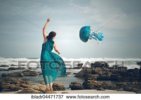 Stock Photo - Woman flying a jellyfish kite at the beach, symbolic image, Cape Recife, Port Elizabeth, South Africa, Africa. Fotosearch