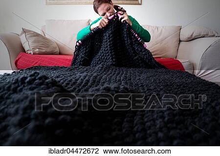 Woman knitting a blanket with large knitting needles View Large Photo Image Stock Image - Woman knitting a blanket with large knitting needles. Fotosearch