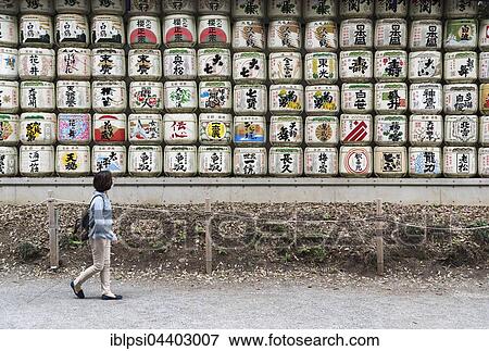 Woman walks pass sake barrels at Meiji Jingu Shrine, Tokyo, Japan, Asia View Large Photo Image Stock Photo - Woman walks pass sake barrels at Meiji Jingu Shrine, Tokyo, Japan, Asia. Fotosearch