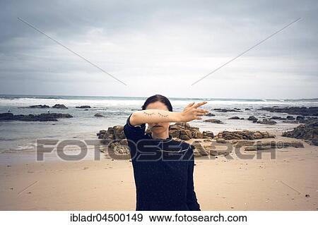 Woman with closed painted on eyes on her arm standing on the beach, behind Sea, South Africa, Africa View Large Photo Image Stock Photo - Woman with closed painted on eyes on her arm standing on the beach, behind Sea, South Africa, Africa. Fotosearch