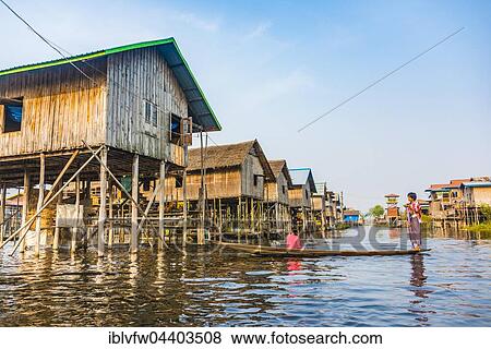 Wooden boat with locals in front of traditional stilt houses on Inle Lake, Nampan, Shan State, Myanmar, Asia View Large Photo Image Stock Photo - Wooden boat with locals in front of traditional stilt houses on Inle Lake, Nampan, Shan State, Myanmar, Asia. Fotosearch