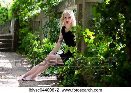 Stock Image - Young blond woman, tattooed. Fotosearch