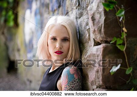 Stock Image - Young blond woman, tattooed. Fotosearch