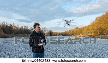 Young man controlling quadcopter, drone with camera flying, DJI Phantom 3, Munich, Upper Bavaria, Bavaria, Germany, Europe View Large Photo Image Stock Image - Young man controlling quadcopter, drone with camera flying, DJI Phantom 3, Munich, Upper Bavaria, Bavaria, Germany, Europe. Fotosearch