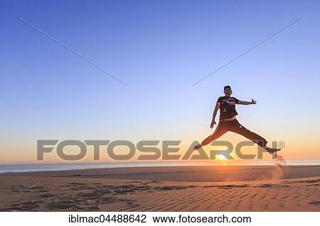 Young man jumping happily in the air, sunset, Namib desert, Langstrand, Swakopmund, Erongo Region, Namibia, Africa View Large Photo Image Stock Image - Young man jumping happily in the air, sunset, Namib desert, Langstrand, Swakopmund, Erongo Region, Namibia, Africa. Fotosearch
