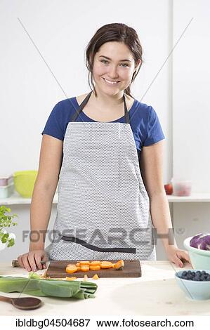 Young woman in the kitchen, chopping vegetables, Munich, Bavaria, Germany, Europe View Large Photo Image Stock Photo - Young woman in the kitchen, chopping vegetables, Munich, Bavaria, Germany, Europe. Fotosearch