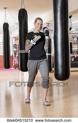Young woman, tattooed, boxing at a sandsack in a boxing studio, Bavaria, Germany, Europe View Large Photo Image Stock Image - Young woman, tattooed, boxing at a sandsack in a boxing studio, Bavaria, Germany, Europe. Fotosearch