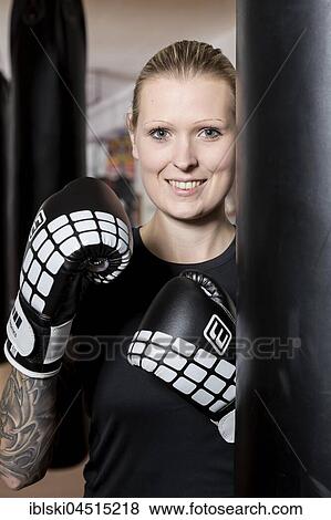 Young woman, tattooed, boxing at a sandsack in a boxing studio, Bavaria, Germany, Europe View Large Photo Image Stock Photo - Young woman, tattooed, boxing at a sandsack in a boxing studio, Bavaria, Germany, Europe. Fotosearch