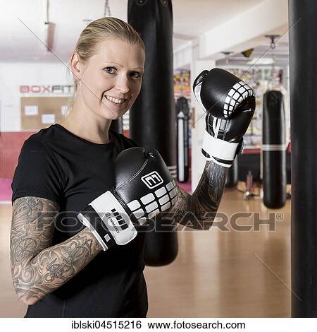 Young woman, tattooed, boxing at a sandsack in a boxing studio, Bavaria, Germany, Europe View Large Photo Image Stock Photograph - Young woman, tattooed, boxing at a sandsack in a boxing studio, Bavaria, Germany, Europe. Fotosearch