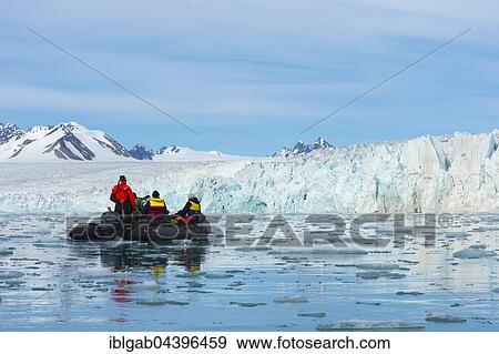 Stock Photo - Zodiac boat with tourists navigating in front of Lilliehook glacier, Lilliehook fjord, Spitsbergen Island, Svalbard Archipelago, Norway, Europe. Fotosearch