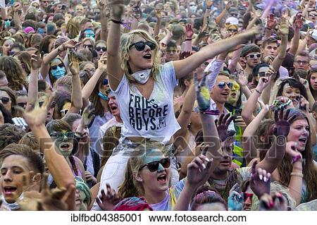 A young woman is sitting on another ones shoulders, raising arms, in the crowd at the colorful Holi festival, Dresden, Saxony, Germany, Europe View Large Photo Image Stock Image - A young woman is sitting on another ones shoulders, raising arms, in the crowd at the colorful Holi festival, Dresden, Saxony, Germany, Europe. Fotosearch