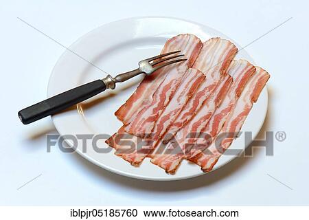 Stock Image - Bacon on plate with fork, bacon strips, breakfast bacon. Fotosearch