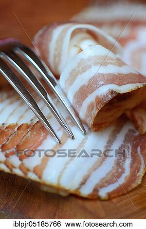 Stock Photograph - Bacon with fork, bacon strips, breakfast bacon. Fotosearch