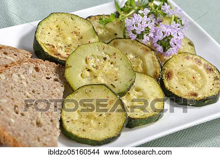 Baked zucchini slices with thyme (Cucurbita pepo) View Large Photo Image Picture - Baked zucchini slices with thyme (Cucurbita pepo). Fotosearch