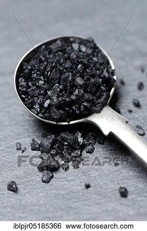 Stock Photograph - Black Hawaiian salt in spoon, lava salt, sea salt with activated carbon. Fotosearch