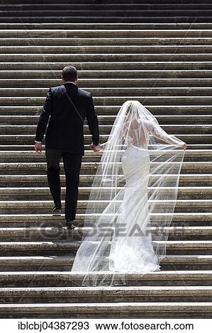 Bride and groom walking up a staircase View Large Photo Image Stock Image - Bride and groom walking up a staircase. Fotosearch