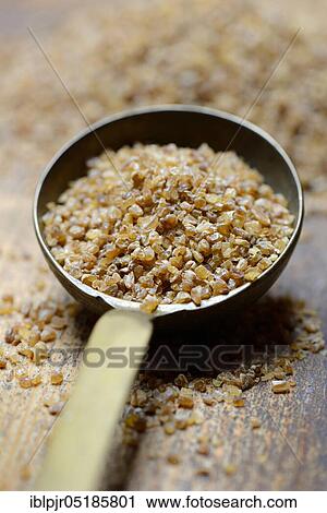 Stock Image - Bulgur, bulgur wheat in ladle, pre-cooked durum wheat. Fotosearch
