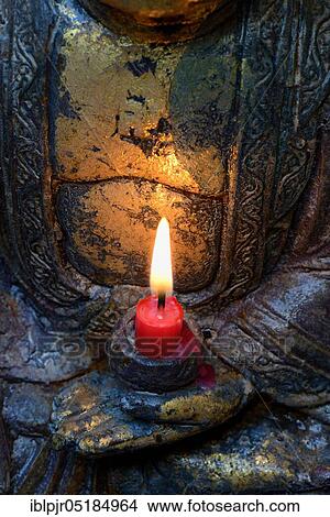 Burning candle with Buddha figure View Large Photo Image Picture - Burning candle with Buddha figure. Fotosearch