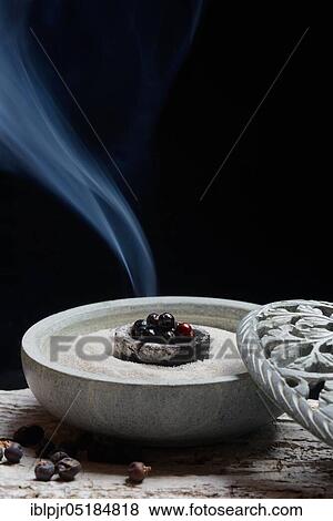 Stock Photo - Burning juniper berries ( Juniperus communis) in shell with sand. Fotosearch