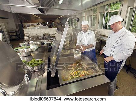 Canteen kitchen in a vocational college in Düsseldorf, trainees manage the school's catering as part of their training, practical lessons in the canteen kitchen, trainee at the tilting frying pan, Düsseldorf, Germany, Europe View Large Photo Image Picture - Canteen kitchen in a vocational college in Düsseldorf, trainees manage the school's catering as part of their training, practical lessons in the canteen kitchen, trainee at the tilting frying pan, Düsseldorf, Germany, Europe. Fotosearch