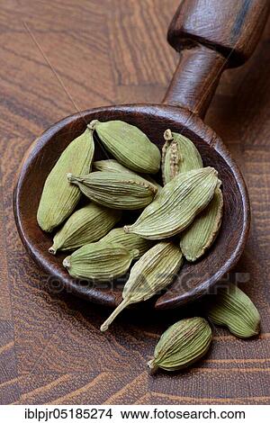 Picture - Cardamom ( Elettaria cardamomum) in wooden spoon. Fotosearch