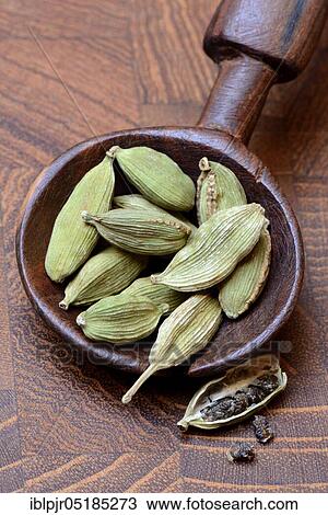 Stock Image - Cardamom ( Elettaria cardamomum) in wooden spoon. Fotosearch