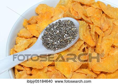 Stock Image - Chia seeds (Salvia hispanica) in spoon and bowl with cornflakes. Fotosearch