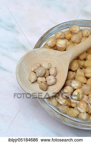 Stock Photograph - Chickpeas ( Cicer arietinum) in wooden ladle, soaked. Fotosearch