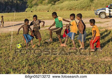 Stock Image - Children playing football at the ferry station across the Manambolo, Bekopaka, Madagascar, Africa. Fotosearch