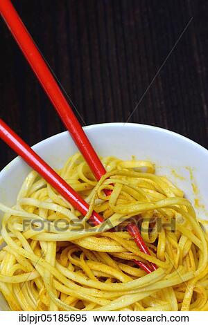 Stock Photography - Chinese noodles in bowl with chopsticks, cooked, nest noodles, curry sauce. Fotosearch