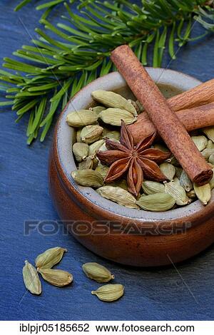 Stock Image - Christmas spices in bowl, cinnamon sticks( Elettaria cardamomum), star anise ( Illicium verum). Fotosearch