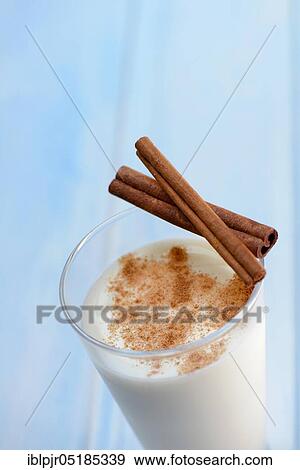 Stock Photo - Cinnamon milk in glass and cinnamon sticks. Fotosearch