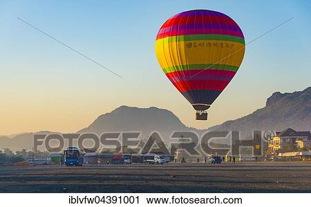 Colorful hot air balloon in the air before landing, back Karst Mountains, Vang Vieng, Vientiane Province, Laos, Asia View Large Photo Image Stock Image - Colorful hot air balloon in the air before landing, back Karst Mountains, Vang Vieng, Vientiane Province, Laos, Asia. Fotosearch
